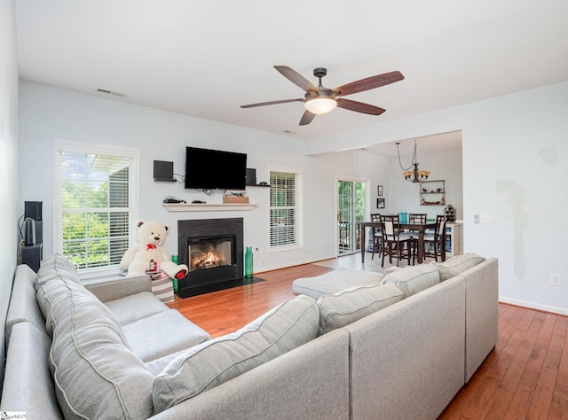 6 Baneberry Ct, Simpsonville, SC 29680 - living room featuring wood finished floors, ceiling fan, a fireplace with flush hearth, baseboards, and a chandelier