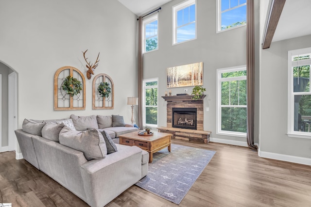 118 Perry Hill Rd, Easley, SC 29640 - living room with arched walkways, a towering ceiling, a fireplace, baseboards, and wood finished floors