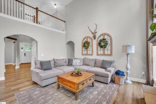 118 Perry Hill Rd, Easley, SC 29640 - living room featuring arched walkways, a high ceiling, wood finished floors, and baseboards