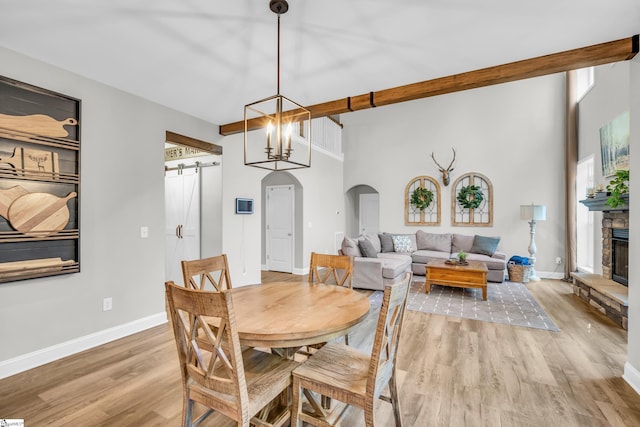 118 Perry Hill Rd, Easley, SC 29640 - dining space featuring arched walkways, light wood-style floors, baseboards, a barn door, and a fireplace