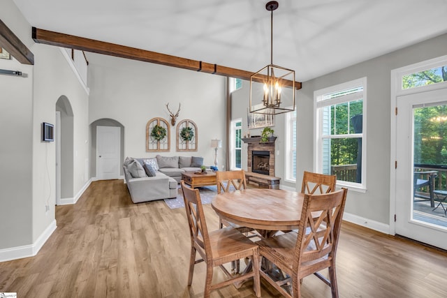 118 Perry Hill Rd, Easley, SC 29640 - dining area with arched walkways, light wood-type flooring, a stone fireplace, baseboards, and a chandelier