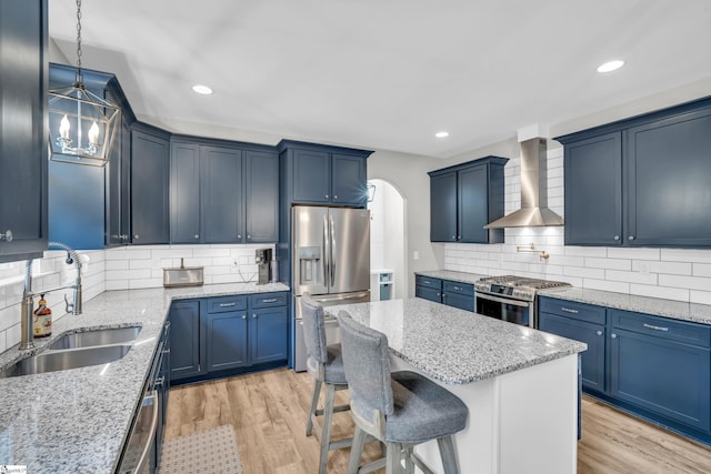 118 Perry Hill Rd, Easley, SC 29640 - kitchen with a sink, wall chimney range hood, stainless steel appliances, a kitchen breakfast bar, and light wood-style flooring