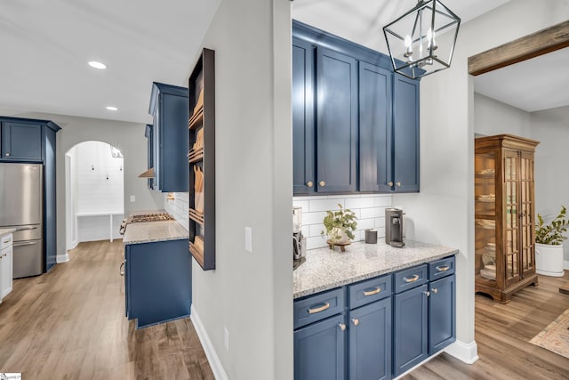 118 Perry Hill Rd, Easley, SC 29640 - kitchen featuring freestanding refrigerator, blue cabinetry, arched walkways, light wood-style floors, and recessed lighting