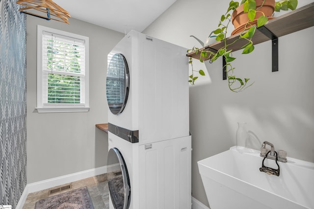 118 Perry Hill Rd, Easley, SC 29640 - full bath with estacked washer and dryer, a sink, baseboards, a freestanding bath, and stone finish floors