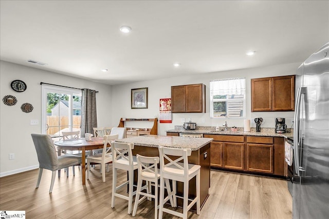 104 Timothy Pl, Easley, SC 29642 - kitchen featuring freestanding refrigerator, light wood-style floors, brown cabinets, a kitchen island, and recessed lighting