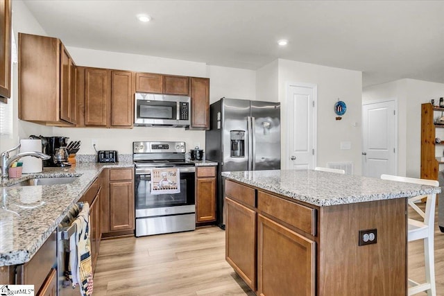 104 Timothy Pl, Easley, SC 29642 - kitchen featuring appliances with stainless steel finishes, a sink, light wood-style floors, light stone counters, and recessed lighting