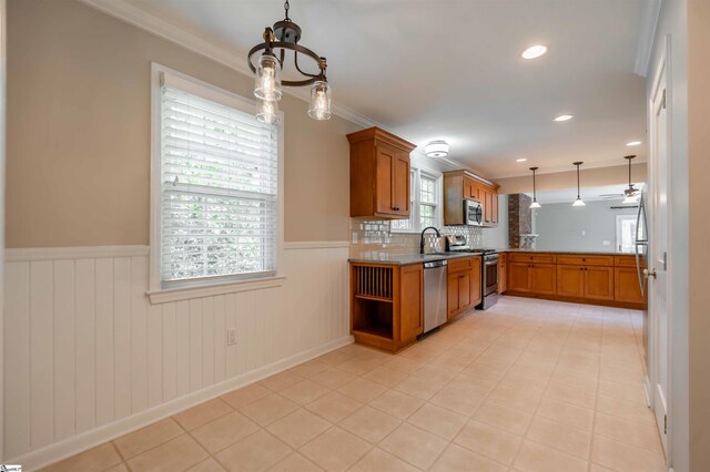 236 S Park Dr, Spartanburg, SC 29302 - kitchen with appliances with stainless steel finishes, a peninsula, ornamental molding, a wainscoted wall, and brown cabinetry