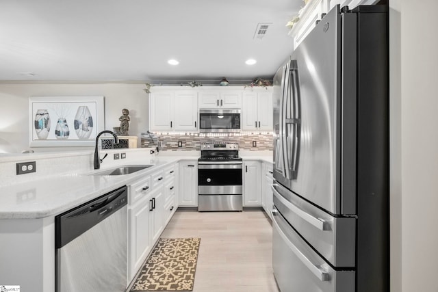 30 Eaglecrest Ct, Simpsonville, SC 29681 - kitchen with appliances with stainless steel finishes, a sink, white cabinets, tasteful backsplash, and light wood-style floors