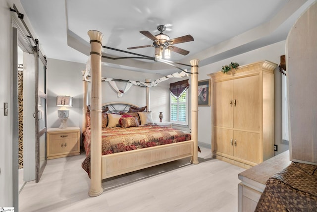 30 Eaglecrest Ct, Simpsonville, SC 29681 - bedroom with a barn door, light wood-style floors, and a ceiling fan