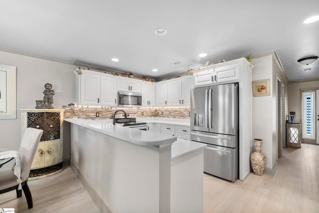30 Eaglecrest Ct, Simpsonville, SC 29681 - kitchen with appliances with stainless steel finishes, a peninsula, crown molding, white cabinets, and light countertops
