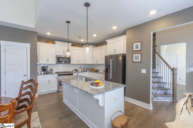 101 Greensdale Ln, Easley, SC 29642 - kitchen with stainless steel appliances, a sink, dark wood-style floors, white cabinets, and tasteful backsplash
