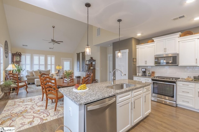 101 Greensdale Ln, Easley, SC 29642 - kitchen featuring stainless steel appliances, a sink, an island with sink, white cabinetry, and high vaulted ceiling