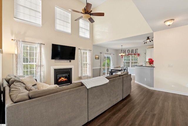 105 Franklin Meadow Way, Greer, SC 29651 - living area featuring dark wood-style floors, a glass covered fireplace, ceiling fan, baseboards, and a towering ceiling