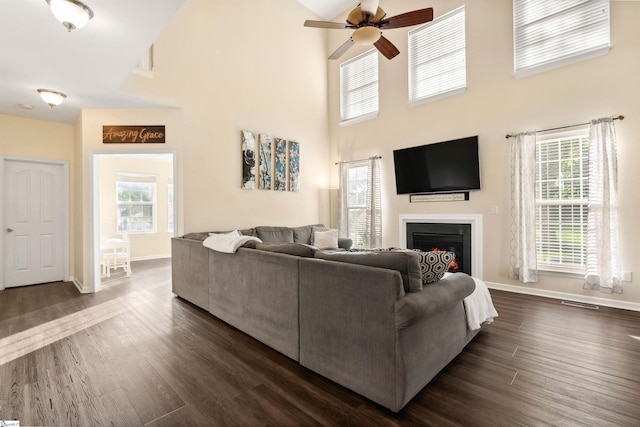105 Franklin Meadow Way, Greer, SC 29651 - living room with a ceiling fan, a lit fireplace, baseboards, dark wood-style floors, and a towering ceiling