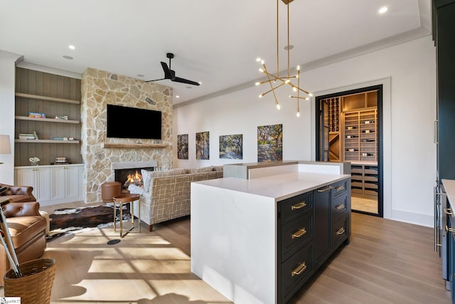 189 Crowne Hill Way, Marietta, SC 29661 - kitchen with open floor plan, light wood-type flooring, light countertops, a stone fireplace, and a ceiling fan