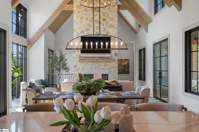 189 Crowne Hill Way, Marietta, SC 29661 - dining area with high vaulted ceiling, a chandelier, a stone fireplace, beam ceiling, and french doors