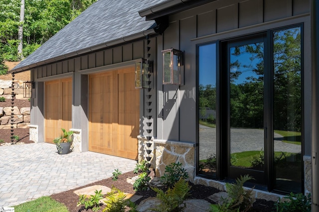 189 Crowne Hill Way, Marietta, SC 29661 - view of exterior entry featuring a shingled roof, board and batten siding, decorative driveway, a garage, and stone siding