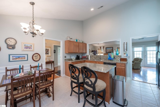 29 River Birch Way, Greer, SC 29650 - kitchen featuring high vaulted ceiling, brown cabinets, a sink, light tile patterned floors, and a chandelier
