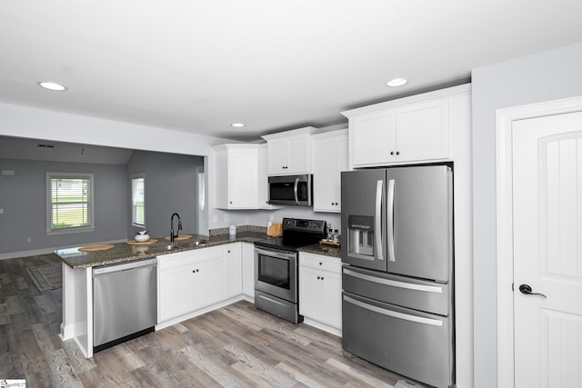 216 Country Gln, Pelzer, SC 29669 - kitchen featuring appliances with stainless steel finishes, a sink, white cabinets, recessed lighting, and light wood finished floors