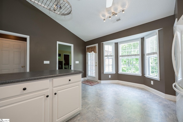 14 Saint Thomas Ct, Greer, SC 29651 - kitchen with dark countertops, freestanding refrigerator, vaulted ceiling, white cabinetry, and baseboards