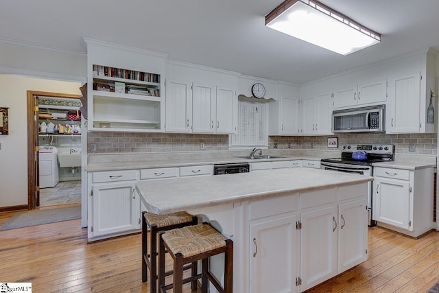 101 N Lady Slipper Ln, Greer, SC 29650 - kitchen with appliances with stainless steel finishes, washer / clothes dryer, light wood finished floors, ornamental molding, and light countertops