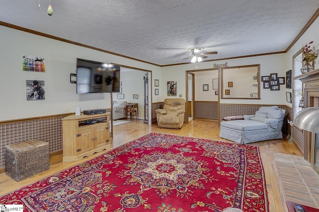 101 N Lady Slipper Ln, Greer, SC 29650 - living room with light wood-type flooring, wainscoting, ceiling fan, crown molding, and a textured ceiling