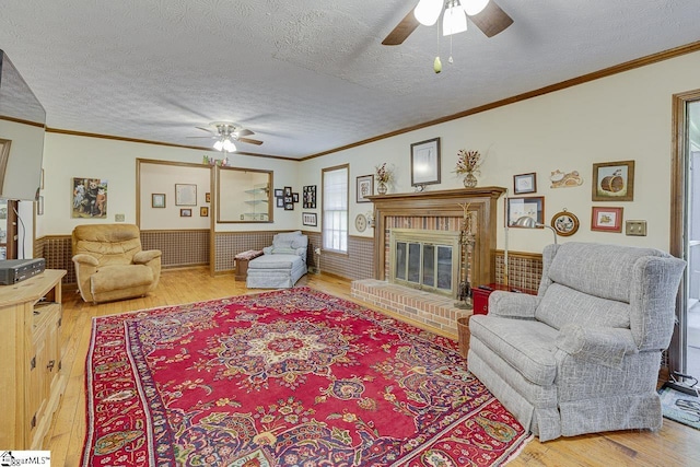 101 N Lady Slipper Ln, Greer, SC 29650 - living area with ceiling fan, light wood-type flooring, a textured ceiling, a wainscoted wall, and ornamental molding
