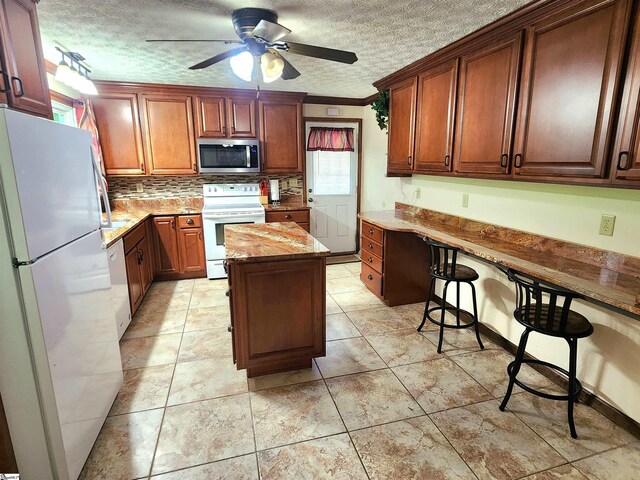 1104 Robert P Jeanes Rd, Easley, SC 29640 - kitchen featuring white appliances, ceiling fan, a textured ceiling, light stone countertops, and backsplash
