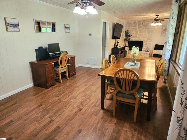 1104 Robert P Jeanes Rd, Easley, SC 29640 - dining space featuring ceiling fan, ornamental molding, wood finished floors, a stone fireplace, and baseboards