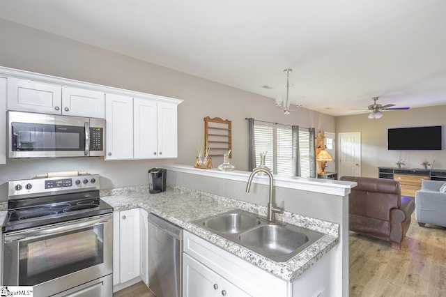 317 Saluda St, Belton, SC 29627 - kitchen with appliances with stainless steel finishes, a peninsula, open floor plan, a sink, and white cabinetry