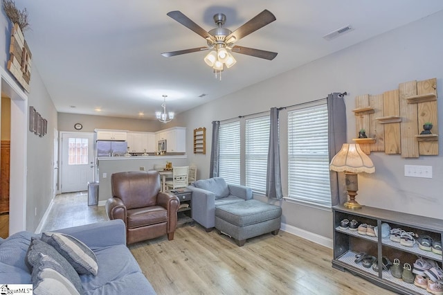 317 Saluda St, Belton, SC 29627 - living room with baseboards, light wood-style floors, ceiling fan, and a chandelier