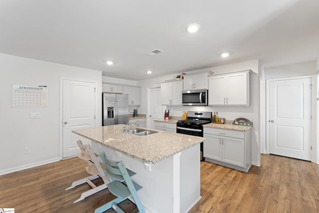 206 Bonifay Dr, Fountain Inn, SC 29644 - kitchen featuring stainless steel appliances, a sink, a center island with sink, light wood-style floors, and a kitchen breakfast bar