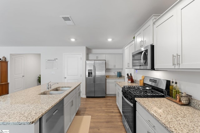 206 Bonifay Dr, Fountain Inn, SC 29644 - kitchen with appliances with stainless steel finishes, a sink, wood finished floors, recessed lighting, and light stone counters