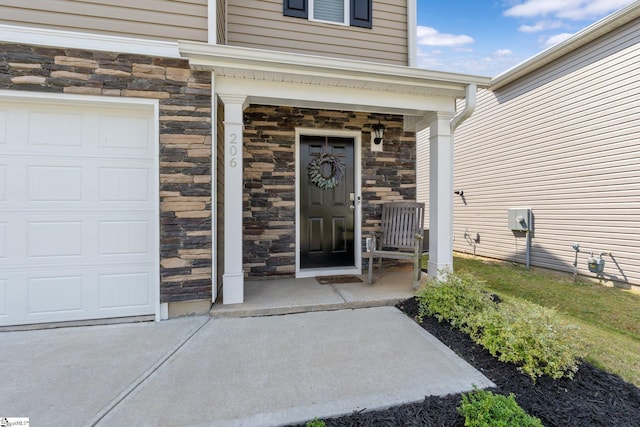 206 Bonifay Dr, Fountain Inn, SC 29644 - doorway to property featuring stone siding, a porch, driveway, and a garage