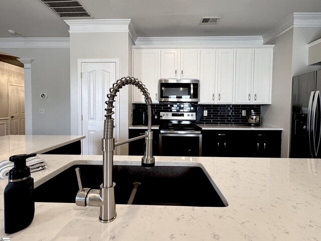 200 Odie Dr, Simpsonville, SC 29681 - kitchen featuring stainless steel appliances, white cabinets, backsplash, light stone counters, and crown molding