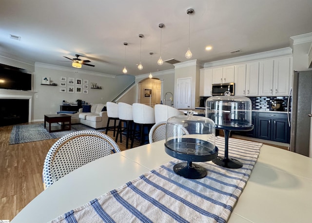 200 Odie Dr, Simpsonville, SC 29681 - dining space with ornamental molding, ceiling fan, a fireplace, and wood finished floors