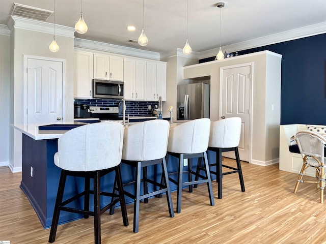 200 Odie Dr, Simpsonville, SC 29681 - kitchen with stainless steel appliances, ornamental molding, backsplash, a breakfast bar, and white cabinetry