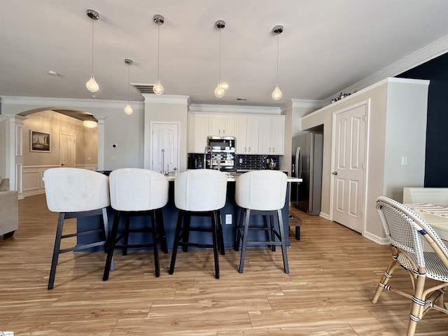 200 Odie Dr, Simpsonville, SC 29681 - kitchen featuring appliances with stainless steel finishes, crown molding, decorative columns, arched walkways, and backsplash