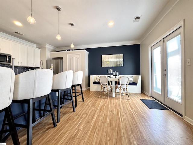 200 Odie Dr, Simpsonville, SC 29681 - kitchen with appliances with stainless steel finishes, french doors, crown molding, white cabinets, and light wood-type flooring