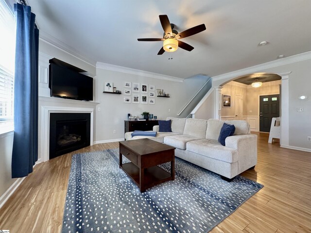200 Odie Dr, Simpsonville, SC 29681 - living room with arched walkways, a ceiling fan, ornamental molding, a fireplace, and decorative columns