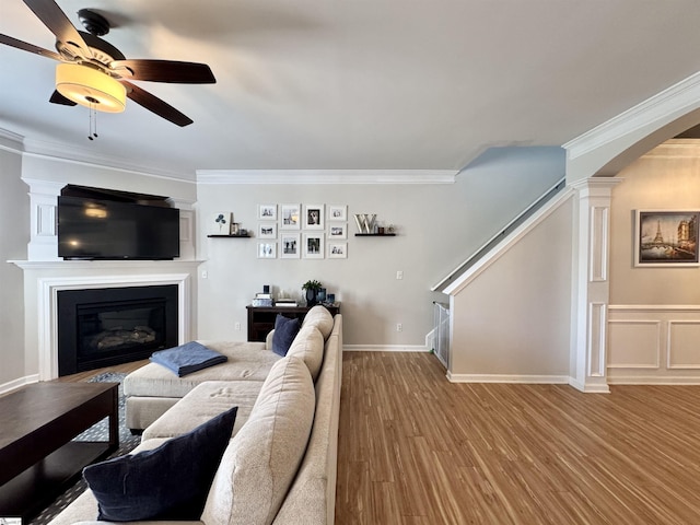 200 Odie Dr, Simpsonville, SC 29681 - living area featuring ornamental molding, wood finished floors, a glass covered fireplace, ceiling fan, and arched walkways