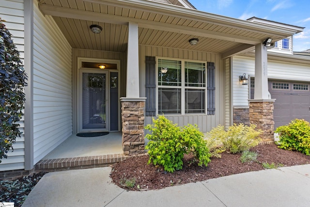 239 Applehill Way, Simpsonville, SC 29681 - view of exterior entry with a porch, stone siding, an attached garage, and board and batten siding