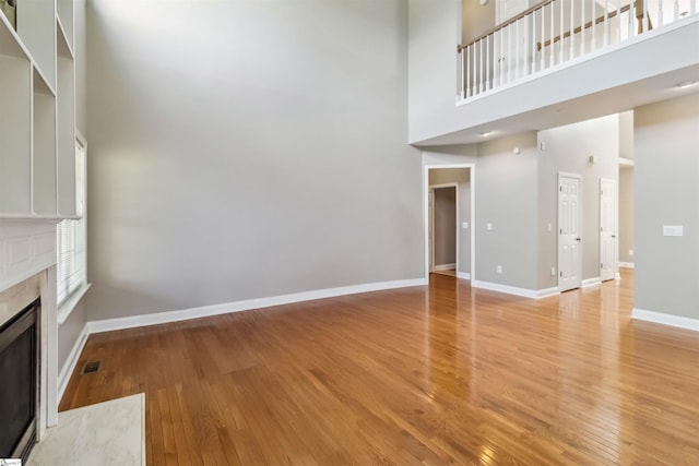 1073 Corie Crest Dr, Boiling Springs, SC 29316 - unfurnished living room featuring a fireplace, a high ceiling, light wood finished floors, and baseboards