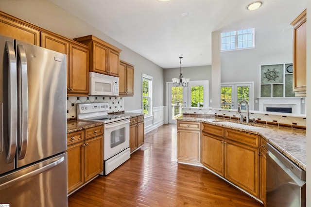 1073 Corie Crest Dr, Boiling Springs, SC 29316 - kitchen featuring stainless steel appliances, a sink, a chandelier, brown cabinetry, and healthy amount of natural light