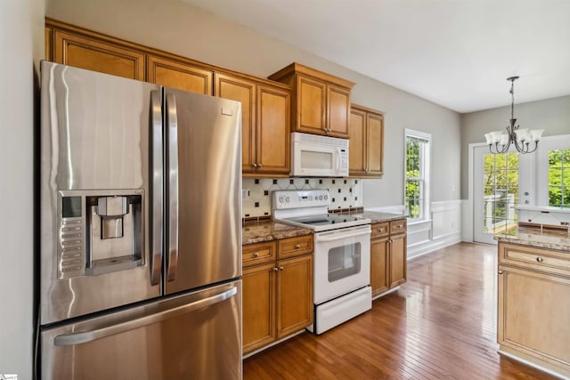 1073 Corie Crest Dr, Boiling Springs, SC 29316 - kitchen with white appliances, plenty of natural light, a chandelier, brown cabinetry, and a wainscoted wall