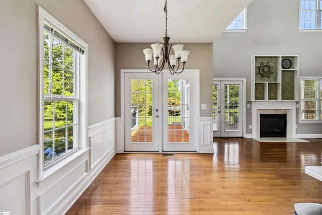 1073 Corie Crest Dr, Boiling Springs, SC 29316 - unfurnished dining area with a chandelier, wainscoting, french doors, wood finished floors, and a decorative wall