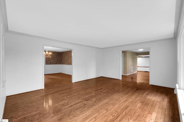 302 Spruce St, Clinton, SC 29325 - empty room featuring wood finished floors, ornamental molding, baseboards, and a chandelier