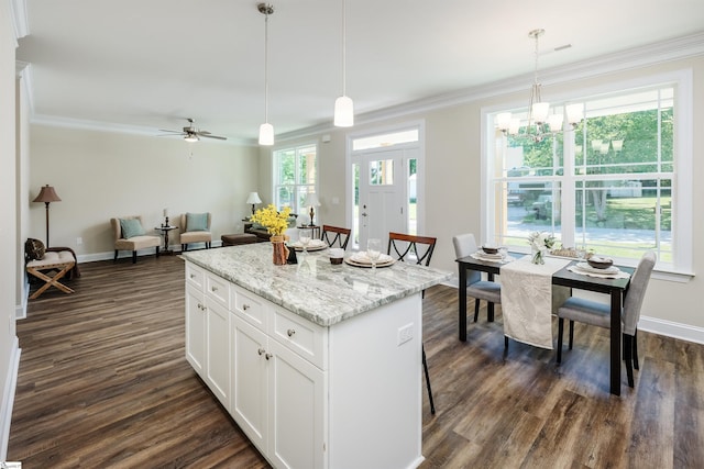 106 N St, Belton, SC 29627 - kitchen featuring a center island, crown molding, dark wood finished floors, pendant lighting, and white cabinets