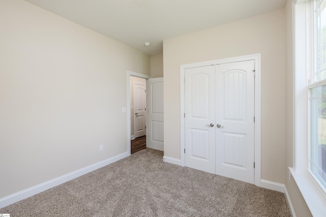 106 N St, Belton, SC 29627 - unfurnished bedroom featuring carpet, a closet, baseboards, and multiple windows