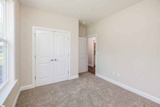 106 N St, Belton, SC 29627 - unfurnished bedroom with carpet flooring, a closet, and baseboards